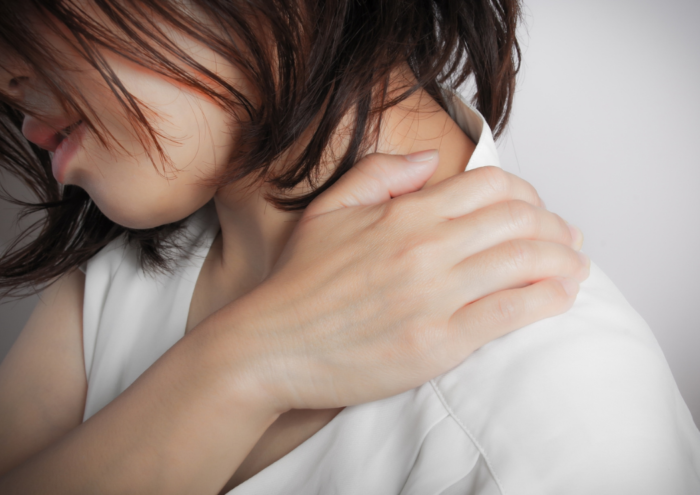 肩甲骨の内側が痛い女性