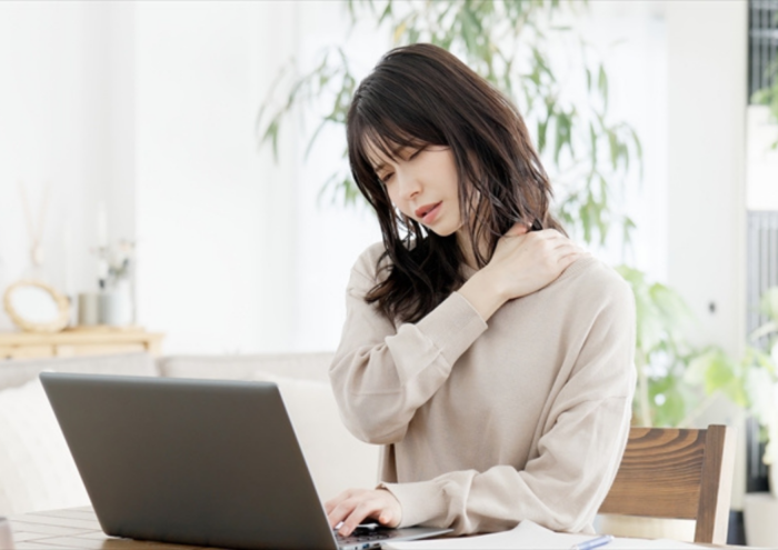 デスクワーク慢性肩こりで首と肩のつらさを感じている女性
